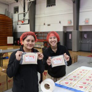 students smiling during meal packing